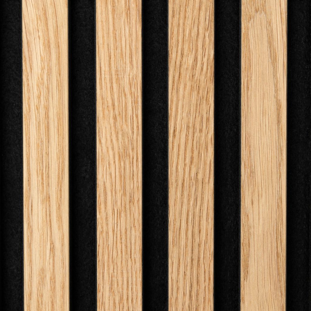 Zdjęcie przedstawia panele lamelowe WoodUpp: pionowe, wąskie listwy dębowe o naturalnym odcieniu i wyraźnym usłojeniu, zamocowane w równych odstępach na czarnym filcowym tle. Matowe, precyzyjnie wykończone listwy tworzą dekoracyjny, akustyczny element wnętrza, doskonałe do ścian, sufitów i paneli akustycznych w biurach lub mieszkaniach.